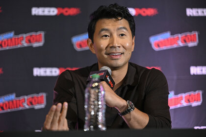Simu Liu talking into a microphone at New York Comic Con.